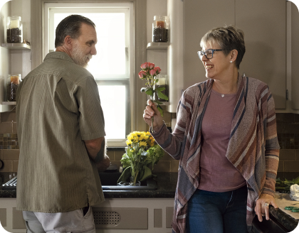 A woman holding a red flower.